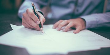 Business man writing on a paper document.