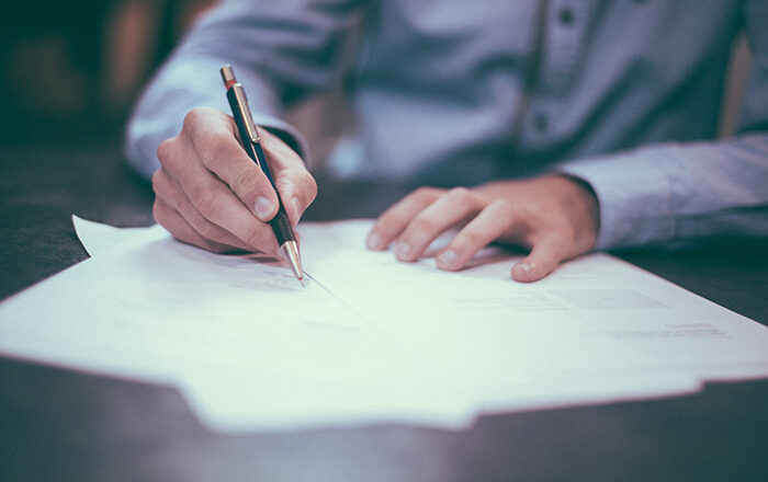 Business man writing on a paper document.