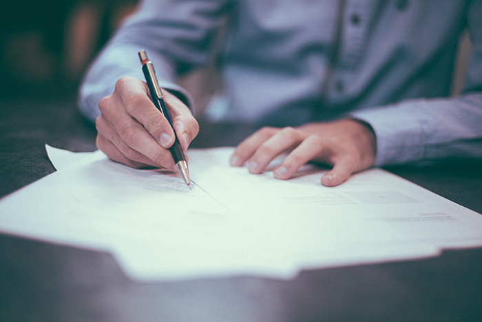 Business man writing on a paper document.