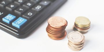 Calculator and three piles of coins.