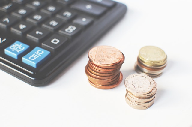 Calculator and three piles of coins.